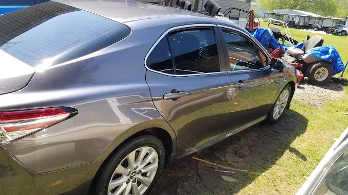 Gray Toyota Camry, rear quarter, with sky reflecting off the trunk